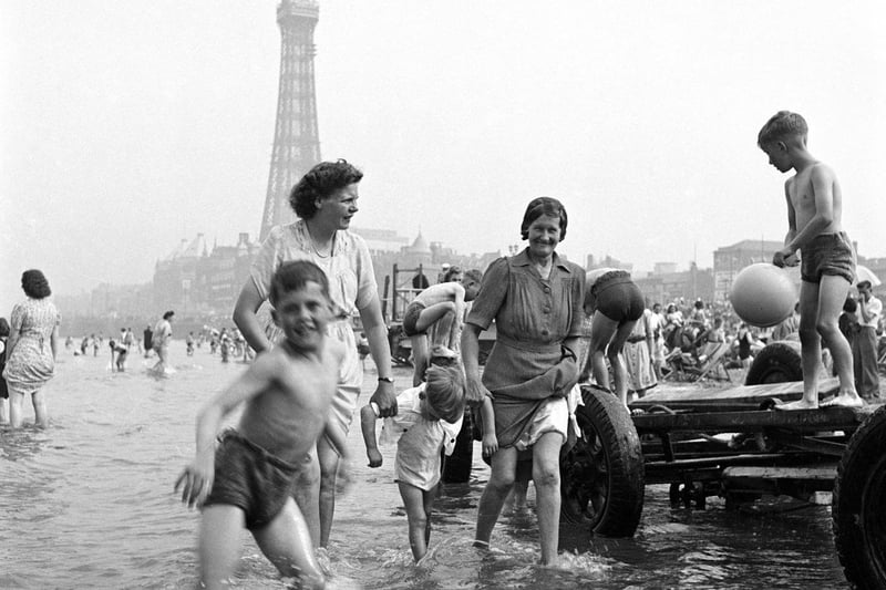 A happy scene as families play in the sea in the shadow of Blackpool Tower