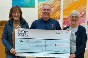 Dave Whitwoth, from DWS Support Services, with two choir members from Encore Singers at the presentation of a cheque for £565.