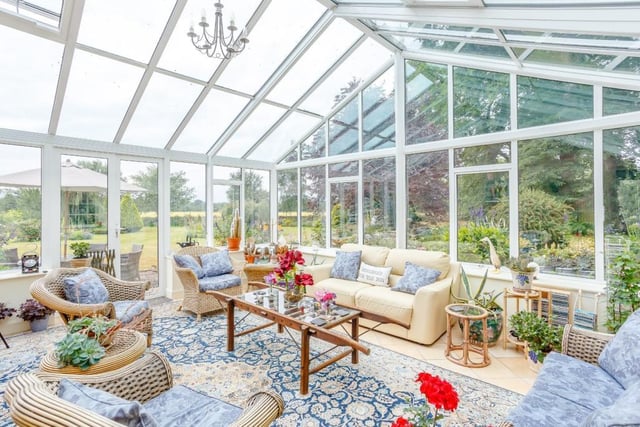 Orangery-style conservatory with vaulted glazed roof, glazing to both aspects and French doors to the garden.