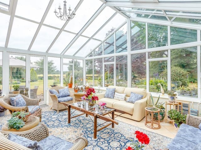 Orangery-style conservatory with vaulted glazed roof, glazing to both aspects and French doors to the garden.