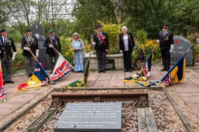 Standards are lowered poignantly towards a replica piece of track from the Burma Star Railway, built by Far East prisoners of war at the Fylde Coast Memorial Arboretum for the VJ Day ceremony