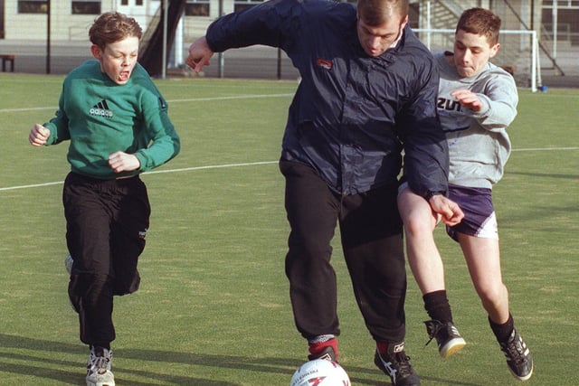 Blackpool FC player Gary Brabin, coaching youngsters at Lytham St. Annes High School in 1997. Trying to tackle him are Chris Enright (left) and Mattie Bancroft.