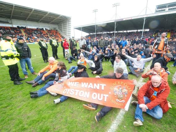 Fans take to the pitch to protest in the game against Blackpool