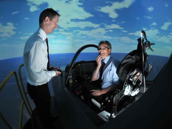 The F35  flight simulator at Warton  used for  training for F35 pilots as the Queen Elizabeth aircraft carrier arrives at Portsmouth after sea trials. Pictured are David Bennett of BAE Systems and reporter Tim Gavell