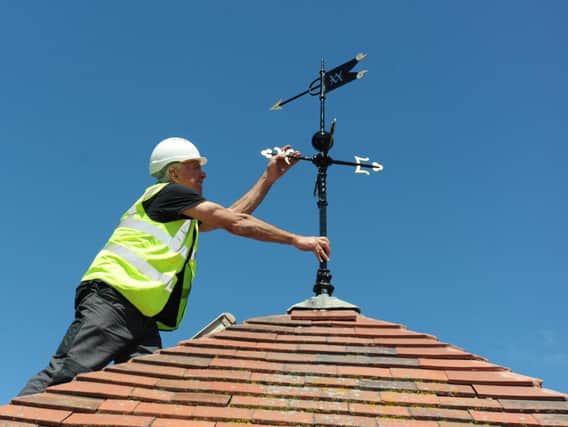 Project manager Bruce Jenkins puts the final touches to the weather vane at Vicarage Park Community Centre
