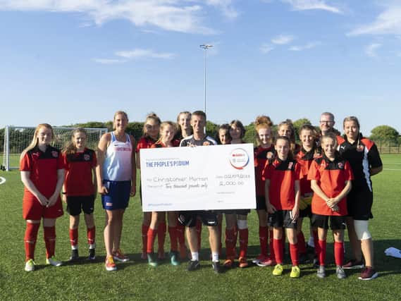 Chris Morton (centre), with GB athlete Holly Bradshaw, players he coaches at Fleetwood Town Juniors and his People's Podium winner's cheque