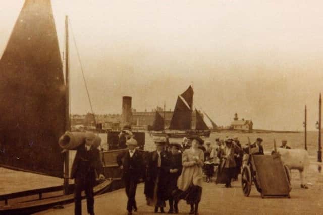 Passengers walk up the Knott End ferry slip with their goods and livestock