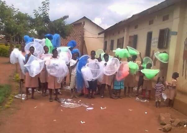 Children at the Kitale School in Uganda receiving the very necessary mosquito nets your club have provided