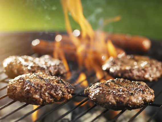 Generic photo of burgers and sausages grilling on a barbecue