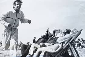 These holidaymakers dont see to have noticed Mike Hamilton, of Park Avenue, Ansdell, as he races along the sands to clock in at the Blackpool Tower, after crossing from the Isle of Man in a yacht in the Tower-Snaefell race. He was placed third in his class