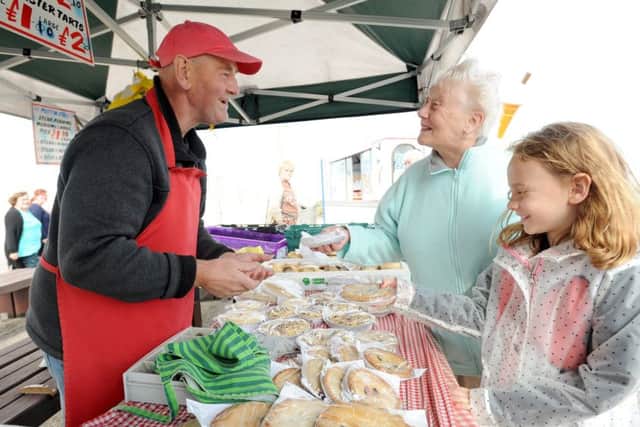 Cleveleys street market at the top of Victoria Road West.  Maureen Vidoretti with granddaughter Lucia, 8, make a purchase from Peter Goodyear from The Muffin Man Ltd.