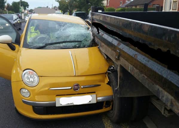 A yellow Fiat 500 car was left embedded in the back of a white Ford tipper truck, and police said its driver blamed the low sun.