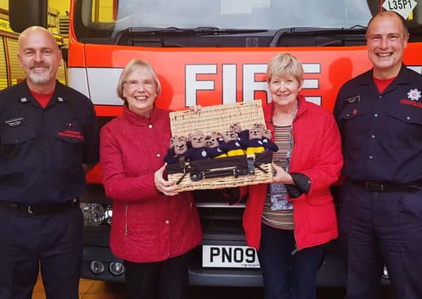 Thelma Band and Lana Ross of the Community Craft Group at St Cuthbert's Church, Lytham  present knitted teddy figures to crew manager Stuart Healey  and firefighter Paul Farman at Lytham Fire Station