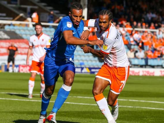 Nathan Delfouneso tussles with Peterborough's Rhys Bennett