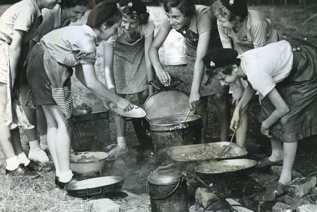 Members of the 3rd Ansdell Girl Guides Company making lunch at their summer camp in Wrea Green