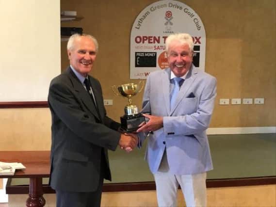Fylde Senior League president Brian Roult presents the Len Hall Trophy for the season's top individual to Dennis McCullough of Herons Reach (right)