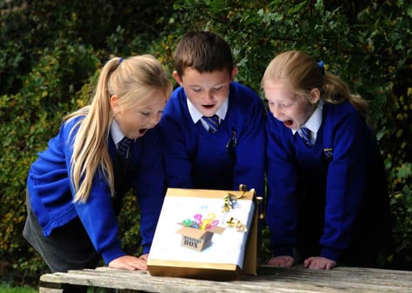 Pupils at Mereside Primary will be learning from 'mystery boxes' this week.  Alice Taylor, Liam Vintner and Molly Foley-Blundell open one of the boxes.