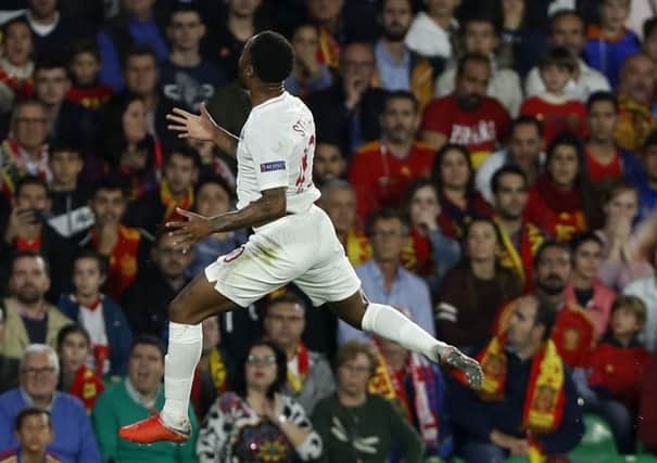 Raheem Sterling jumps for joy after opening the scoring in Seville