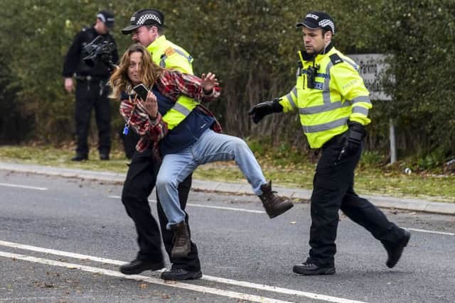 A fracking protester is hurled to the floor by police as she attempts to stop a large HGV lorry bound for the Cuadrilla fracking site on Preston New Road in Blackpool this morning (TUES) - 16th September 2018