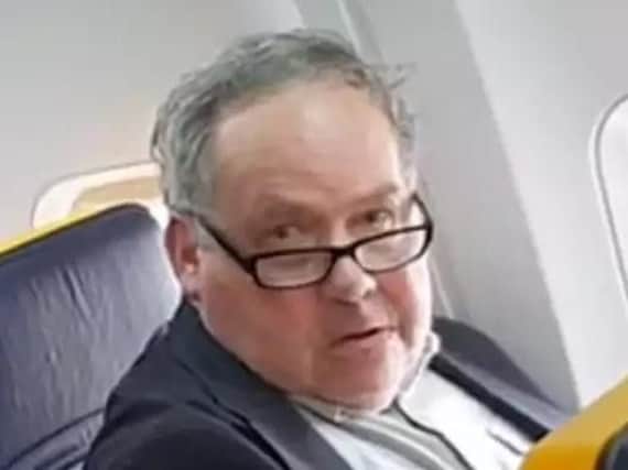 The Ryanair passenger who launched a tirade at an elderly woman has apologised and denied he is a racist.