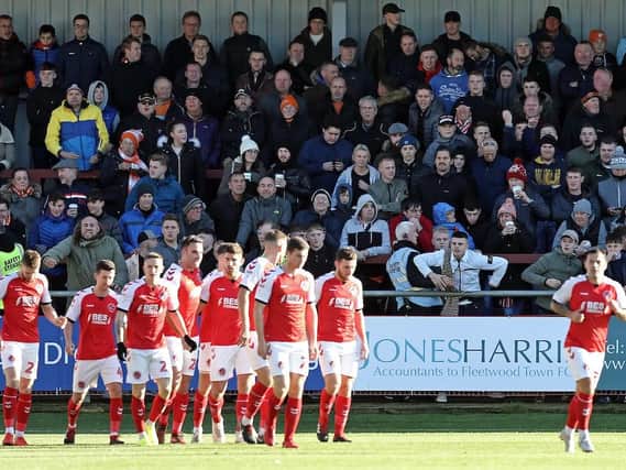 Blackpool fans look on as Fleetwood Town players celebrate their opening goal