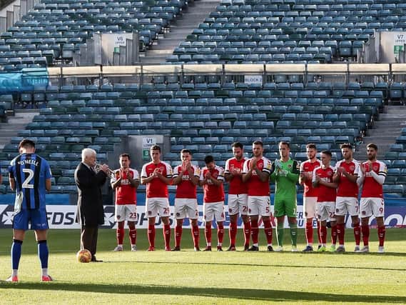 The Fleetwood and Gillingham players observe a minute's silence