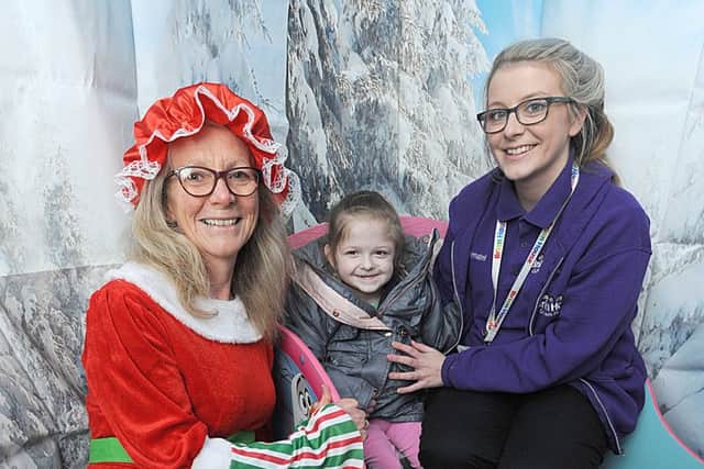 Children from Brian House visit Santa's Grotto at Jellytots.  Santa's helper Mary Booth with 7-year-old Elena Williams and Annabel Bromilow.