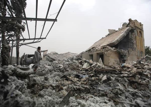 A man stands on the rubble of a house destroyed by a Saudi-led airstrike on the outskirts of Sanaa, Yemen, Tuesday, June 9, 2015. A series of airstrikes from the Saudi-led military coalition also targeted Yemen's Defense Ministry building, which is under control of Shiite rebels who control the capital, Sanaa, officials said. (AP Photo/Hani Mohammed)
