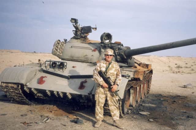Paul Corlett in front of an abondoned Iraqi tank on the road to Basra / Iraq war