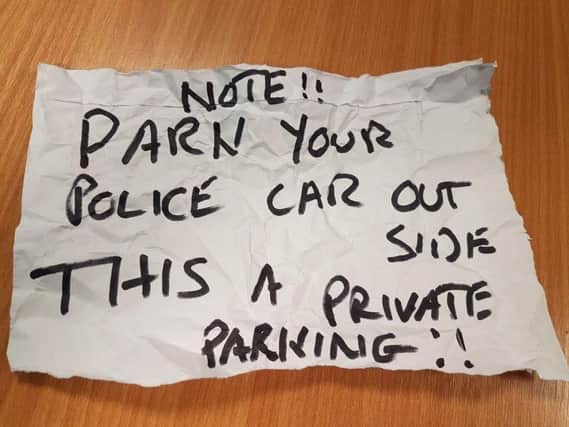 Surrey Police handout photo of an angry note that was put on a police car while officers attended a "potentially life or death situation" involving a distressed neighbour. Photo credit: Surrey Police/PA Wire