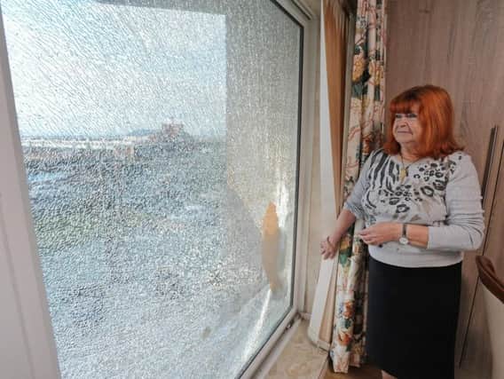 Rita Birch stands next to the shattered window which is in her terminally ill husbands room