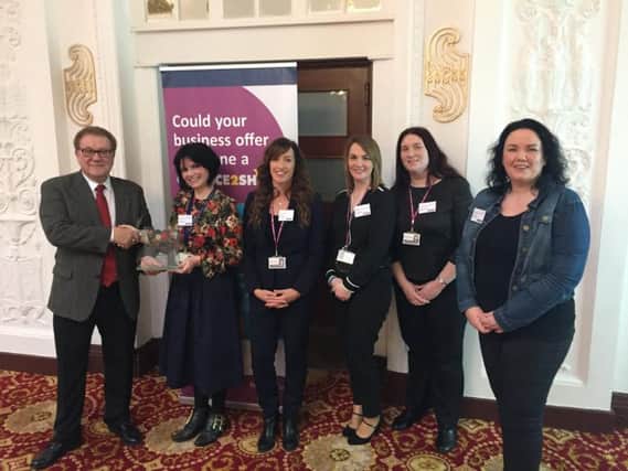 Rod Natkiel, chief executive of Fair Train, left, presents the gold standard award to the team from Chance2Shine and coun Gillian Campbell, right