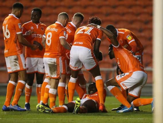 The Blackpool players swamp Joe Dodoo after he acrobatically scored their third