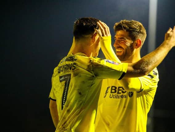 Ched Evans congratulates Wes Burns on his goal at Guiseley