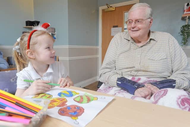 Children from Little Angels Nursery regularly pay a visit to residents at Amber Court Care Home.  Pictured is 3-year-old Florence North with resident champion Paul Burgess.