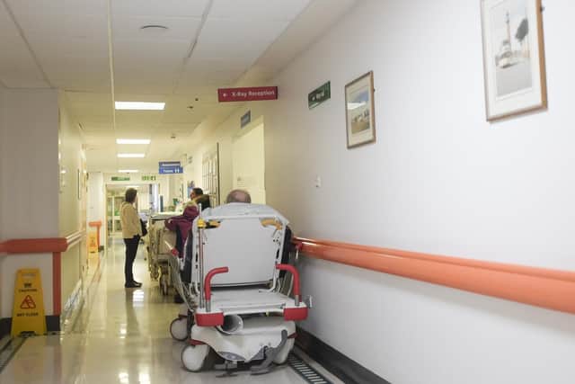 Patients waiting on trolleys in corridors