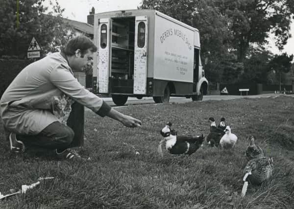 Official duck feeder Derek Priestley gives the Wrea Green ducks their daily treat, in September 1983. Derek is paid is a nominal sum by the parish council to feed the ducks each day as he passes in his mobile shop.
