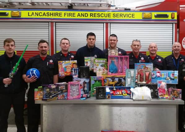 Fire crew from Fleetwood Fire Station will gifts they are donating to the Wish Tree Appeal, organised by PCSO Linda Stackhouse (far right).