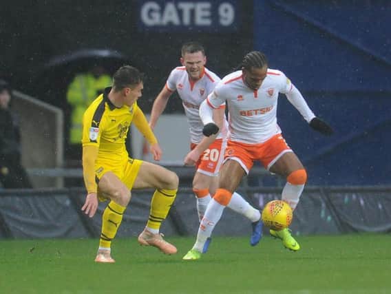 Ollie Turton watches on as Nathan Delfouneso battles to keep hold of possession