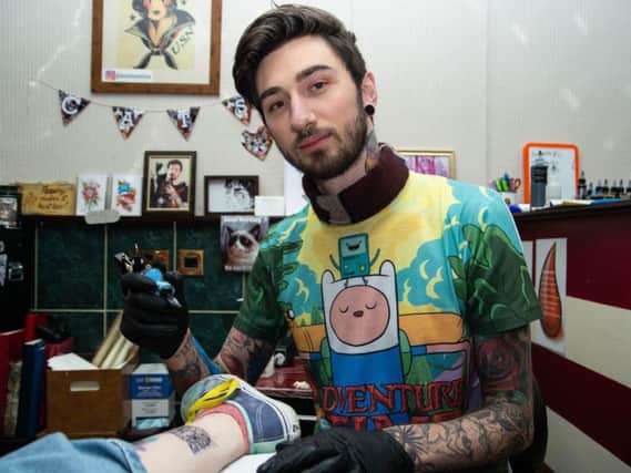 Damian Hope Ellams completes a tattoo at Hellow Sailor Tattoo Studio.