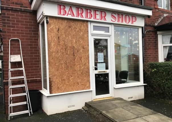 The boarded-up window at the Barber Shop in Thornton after a burglary.