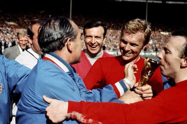 File photo dated 30-07-1966 of England manager Alf Ramsey (third l) is congratulated by trainer Harold Shepherdson (l), squad members Ron Springett (second l) and Jimmy Armfield (c), and Nobby Stiles (r) as captain Bobby Moore (second r) presents him with the Jules Rimet trophy after England's 4-2 win