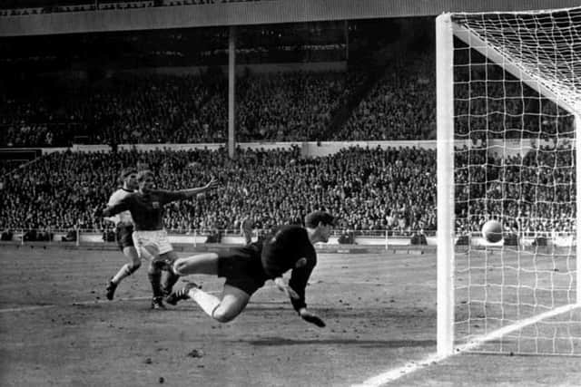 England's controversial third goal scored by Geoff Hurst (not shown) in the World Cup Final on July 30, 1966 at London's Wembley Stadium. German goalkeeper Hans Tilkowski dives for the ball watched by England's Roger Hunt (dark shirt). After consulting with the linesman the referee decided the ball had crossed the line after the shot hit the crossbar and rebounded down. England won the final 4-2 after extra-time.