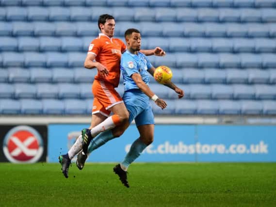 Coventry City's Jonson Clarke-Harris shields the ball from Blackpool's Ben Heneghan