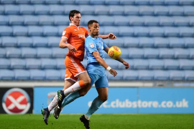Coventry City's Jonson Clarke-Harris shields the ball from Blackpool's Ben Heneghan