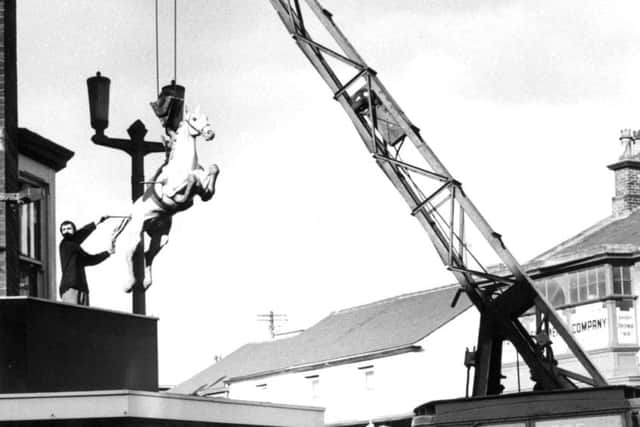 Fox Brothers of Blackpool lift the horse statue into place onto Hunters shop, in 1964