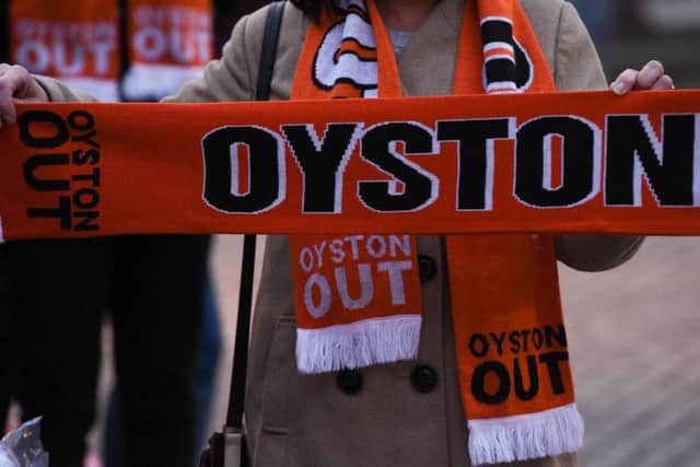 A Blackpool FC fan holds up an Oyston Out scarf. Photo: Getty Images