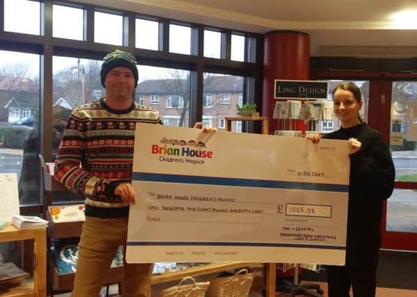 Tim Holloway presents a cheque to Brian House Children's Hospice after raising donations through decorating his house in Christmas lights