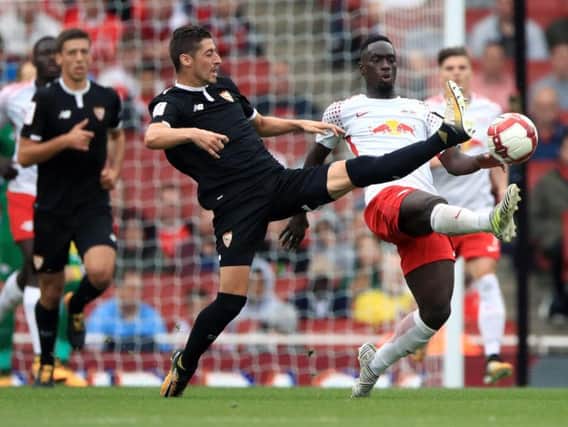 RB Leipzig's Jean-Kevin Augustin (right) and Sevilla's Sergio Escudero battle for the ball during the Emirates Cup match at the Emirates Stadium