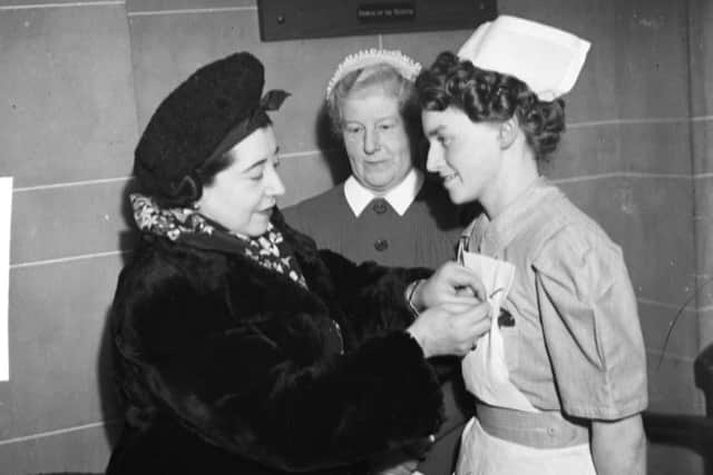 Actress and comedienne Yvonne Arnaud pinning the William Hammond Hodgson gold medal for 1947 on the uniform of nurse D A Longworth at Blackpool Victoria Hospital. In the centre is the Matron Miss E H MacLean.
